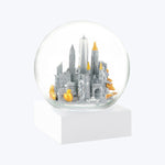 Snow globe with stylized urban skyline, gold and silver accents.