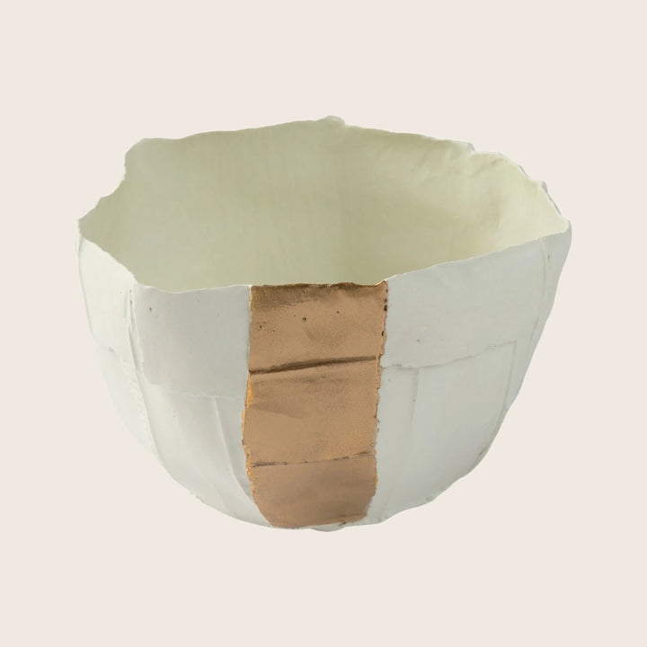 Ceramic bowl repaired with gold-toned material resembling kintsugi technique.
