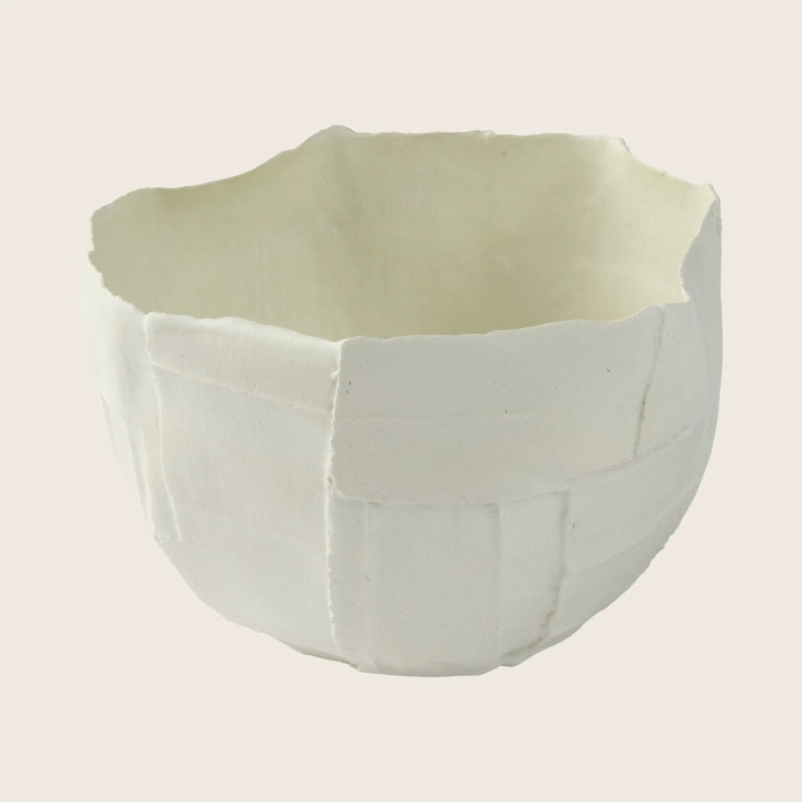 Handcrafted ceramic bowl with wavy rim and textured surface design.