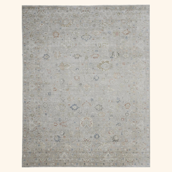 Rectangular area rug with faded, distressed traditional pattern in neutrals.