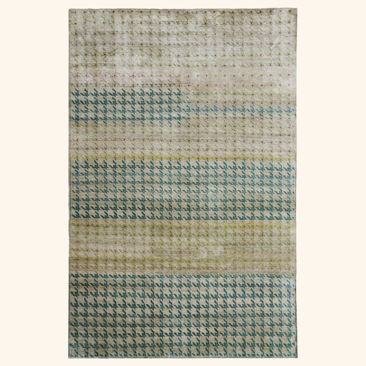 Handwoven rug with teal gradient and repeating pattern design detail.