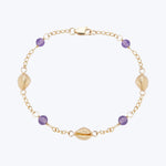 Delicate gold bracelet with shell charms, purple gems, and clasp.