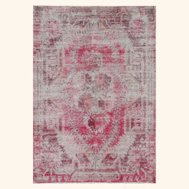 Vintage distressed pink and grey area rug with floral medallion.