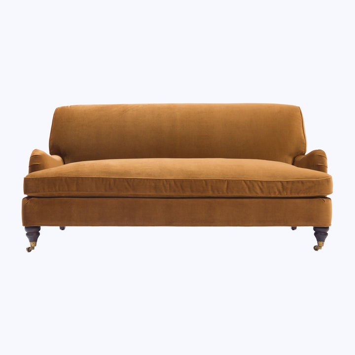 Traditional camel velvet sofa with rolled arms and wooden legs.