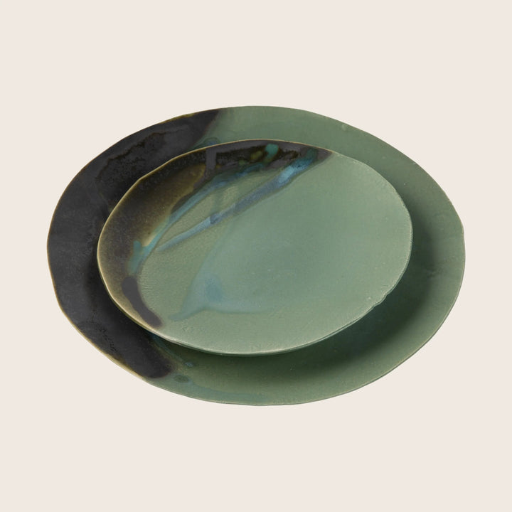 Two stacked ceramic plates showcasing contrasting textures and finishes