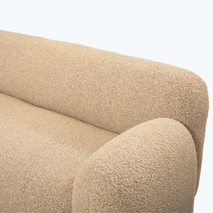 Close-up of tan textured sofa with smooth, curved design.