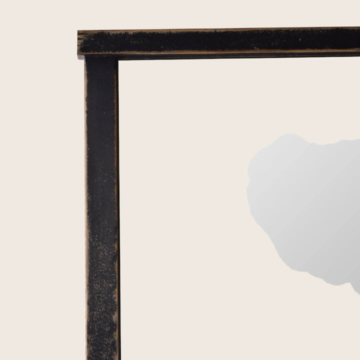 Aged black picture frame corner with white interior detail.