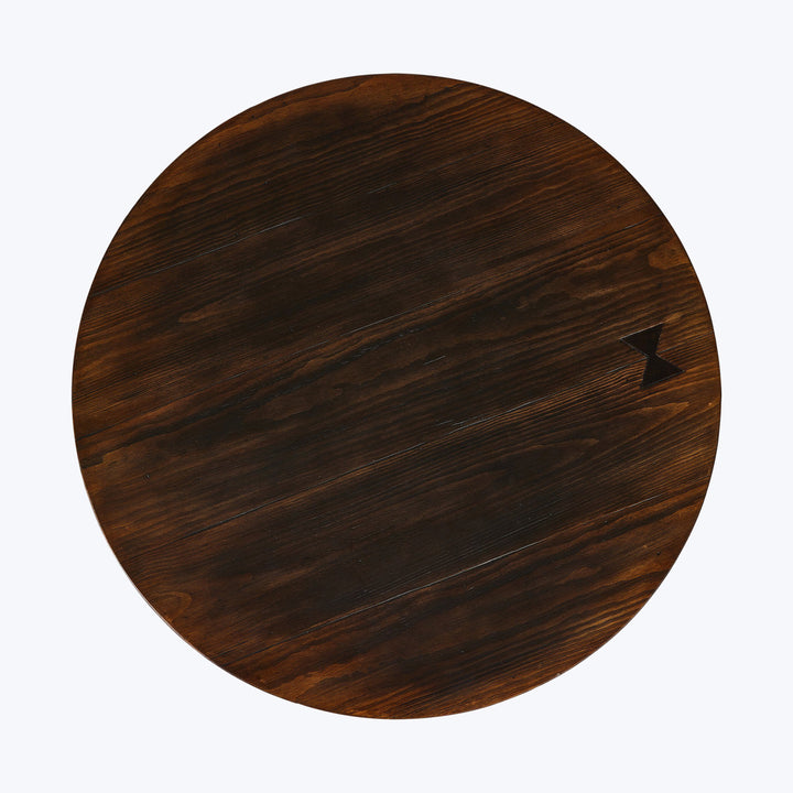 Round wooden table top with dark brown grain texture, scratches.