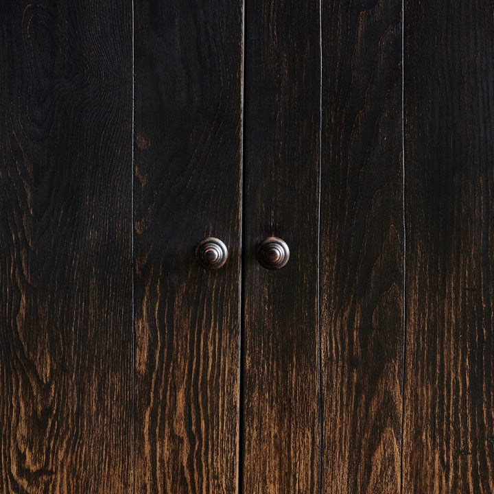 Close-up of dark stained wooden surface with metal knobs