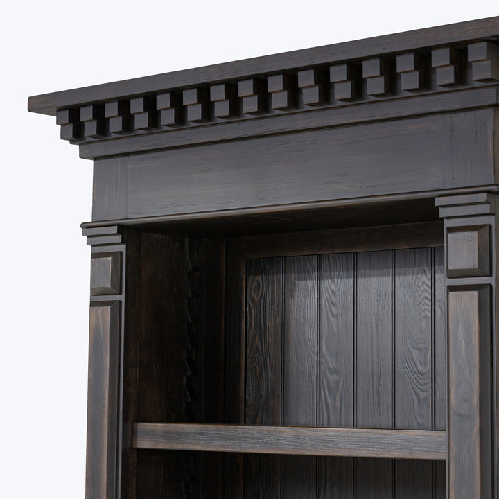 Close-up of traditional dark wooden fireplace mantel with decorative details.