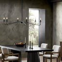 Modern dining room with sleek table, chandelier, and minimalist decor.