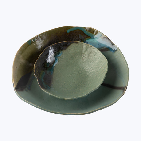 Handcrafted ceramic plate with unique green glazing and metallic sheen.