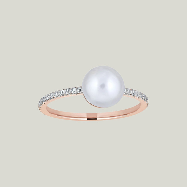 Elegant rose gold ring with diamond embellishments and large pearl.