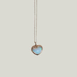 Golden heart pendant with opalescent stone on chain, elegant jewelry