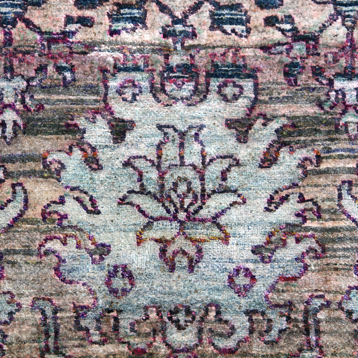 Traditional floral motif textile in muted colors, well-worn with intricate detail.