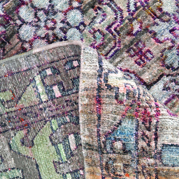 Intricate handmade rug with geometric patterns in varied colors.