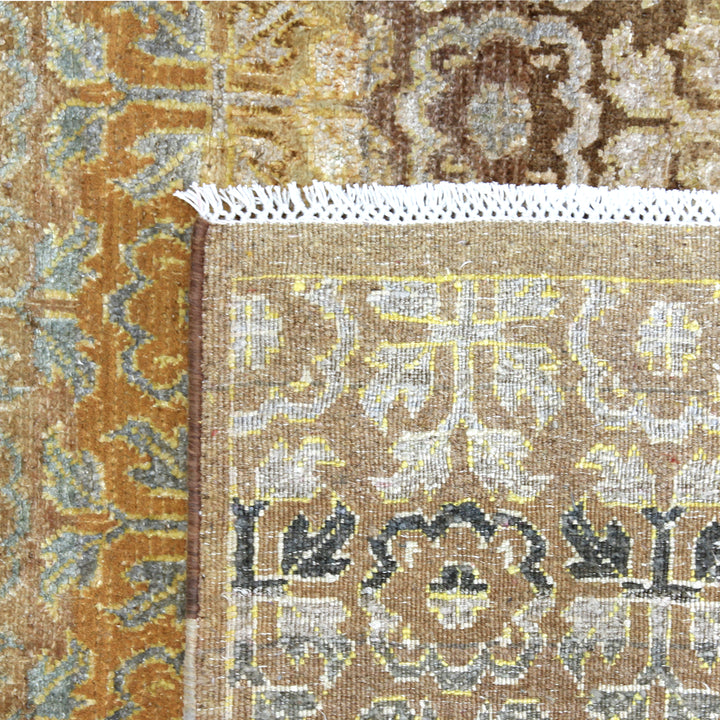 Intricate floral rug with folded corner reveals detailed woven structure.