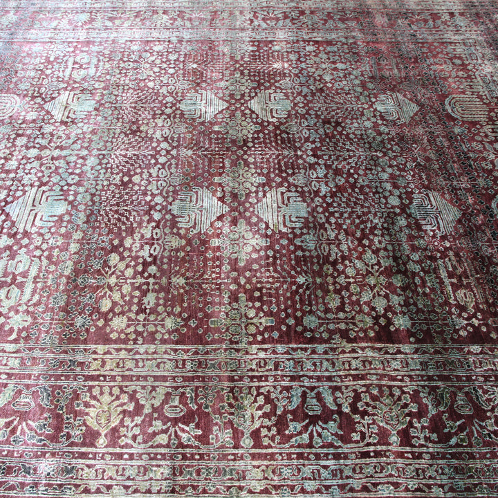 Intricate red and beige patterned rug with geometric and floral motifs.