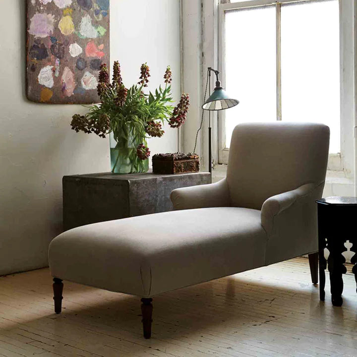 Vintage minimalist interior with elegant chaise lounge and natural lighting.