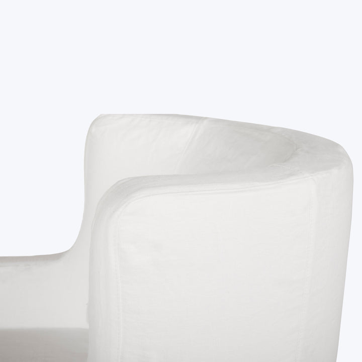 Close-up of white fabric-covered furniture piece, possibly chair or sofa.
