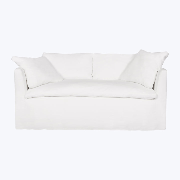 Minimalist white sofa with sleek design and soft fabric cushions.