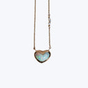 Heart-shaped pendant necklace with iridescent stone and delicate chain.