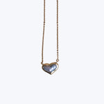 Elegant heart-shaped pendant necklace with iridescent pearl, gold-toned setting.