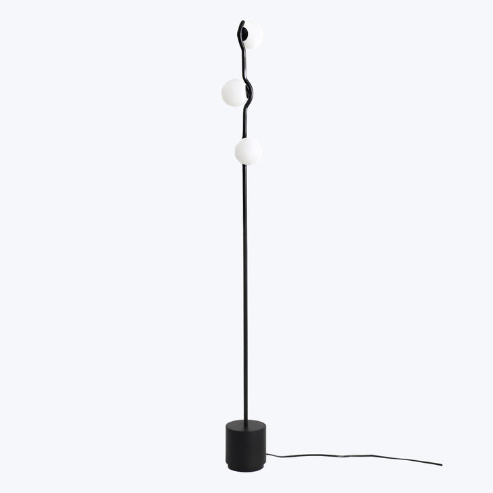 Modern floor lamp with minimalist design, featuring wavy pole.