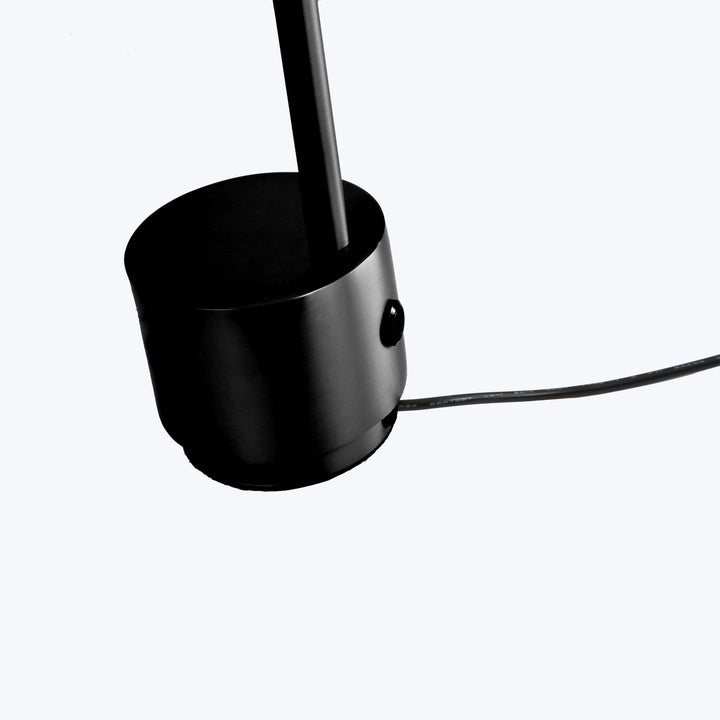 Modern black minimalist lamp with cylindrical base and sleek design.