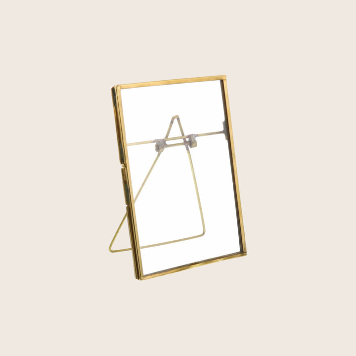 Empty standing photo frame with golden border and back stand.