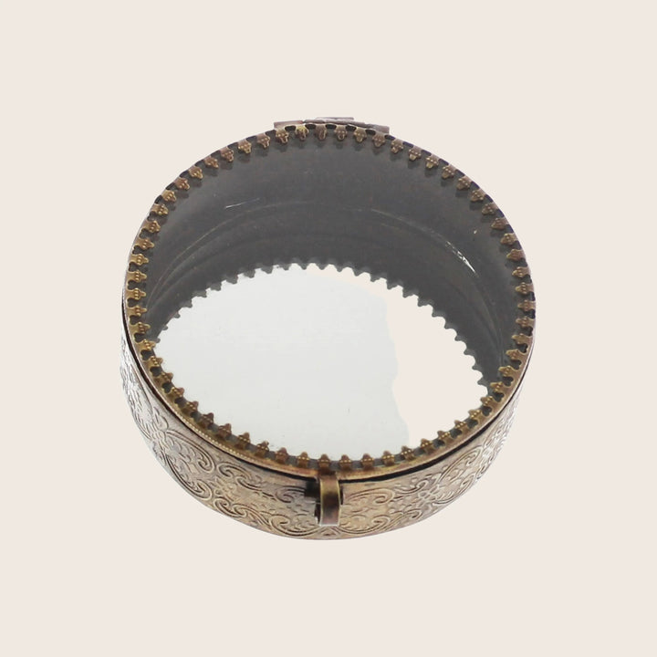 Antique metal grinder with ornate design and intricate engravings.
