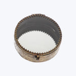 Antique metal grinder with ornate design and intricate engravings.