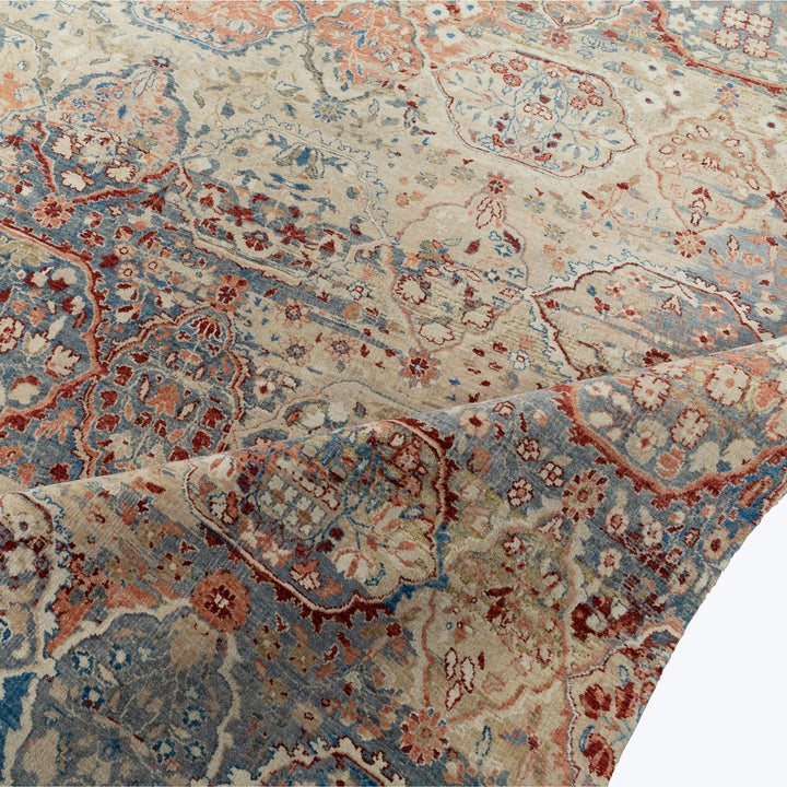 Close-up of ornate carpet with traditional floral design in blue.