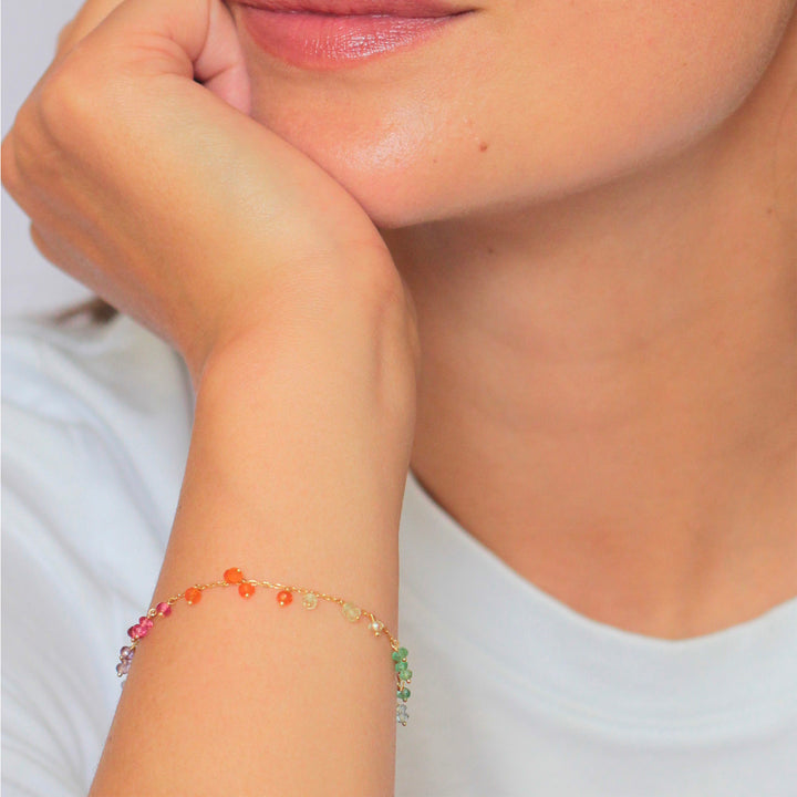 Dainty gemstone bracelet showcased on person's wrist, soft lighting used.