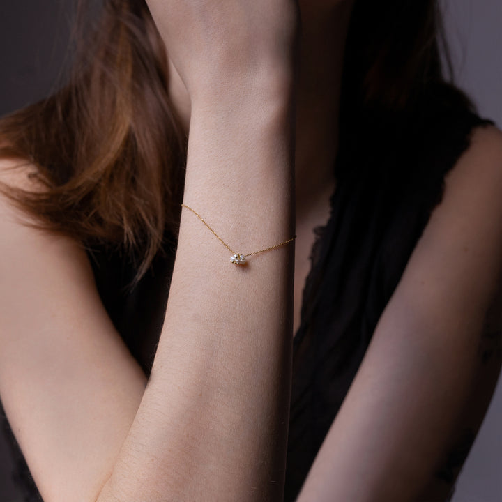 Close-up of person's left arm with dainty gold bracelet.