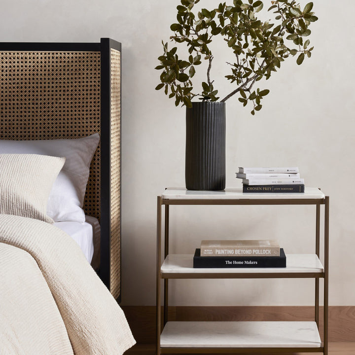 Modern and elegant bedroom detail with geometric headboard and decor.