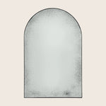 Arch-shaped freestanding mirror with textured glass and sleek frame design.