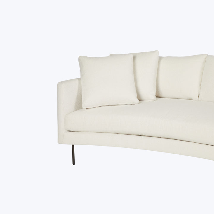 Modern sectional sofa with light upholstery and slim dark legs.
