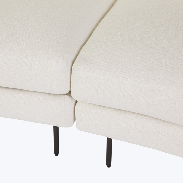 Modern light-colored sectional sofa with simple design and textured fabric.