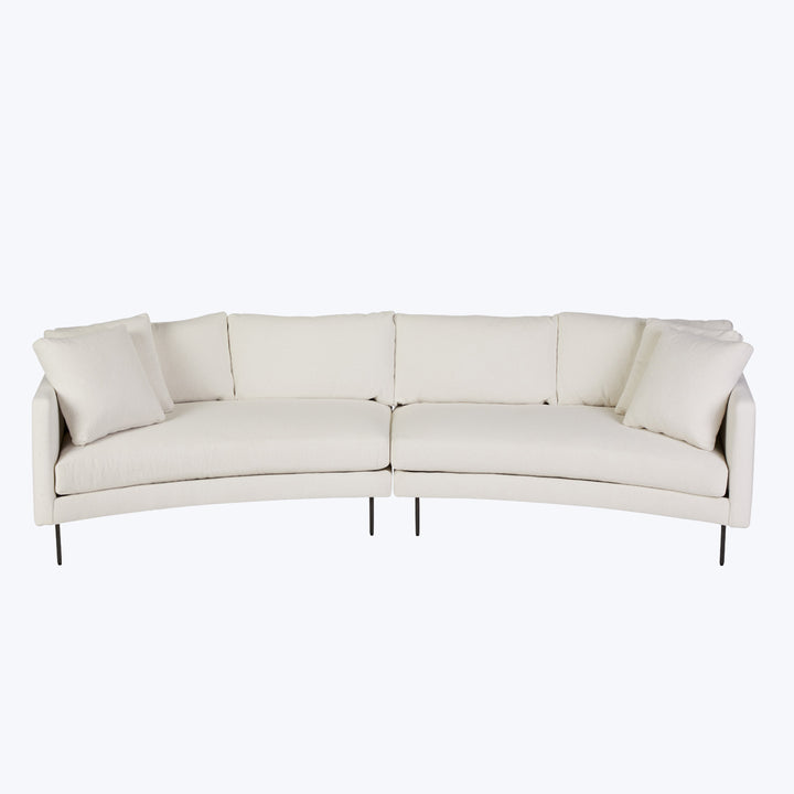 Modern sectional sofa with light upholstery and slim black legs.