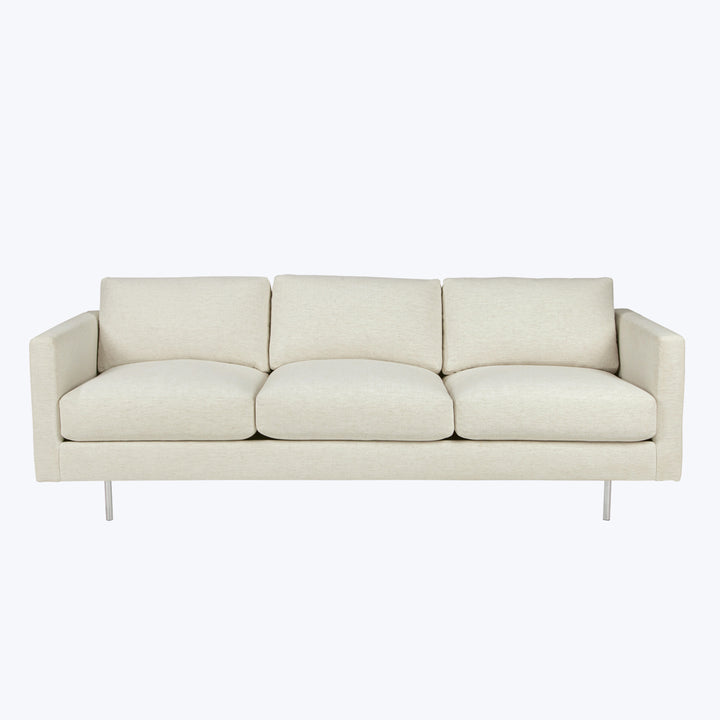 Sleek, modern three-cushion sofa in light beige fabric with metallic legs.