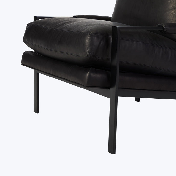 Modern black leather armchair with metal frame and squared shape.