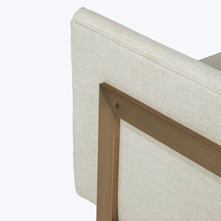 Modern, minimalist chair with light fabric upholstery and wooden frame.