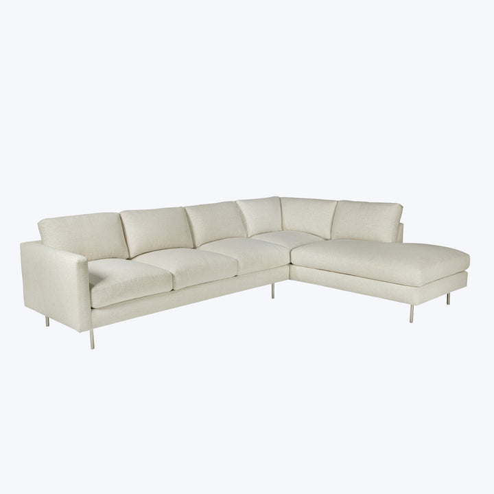 Modern L-shaped sectional sofa in light beige with metal legs.