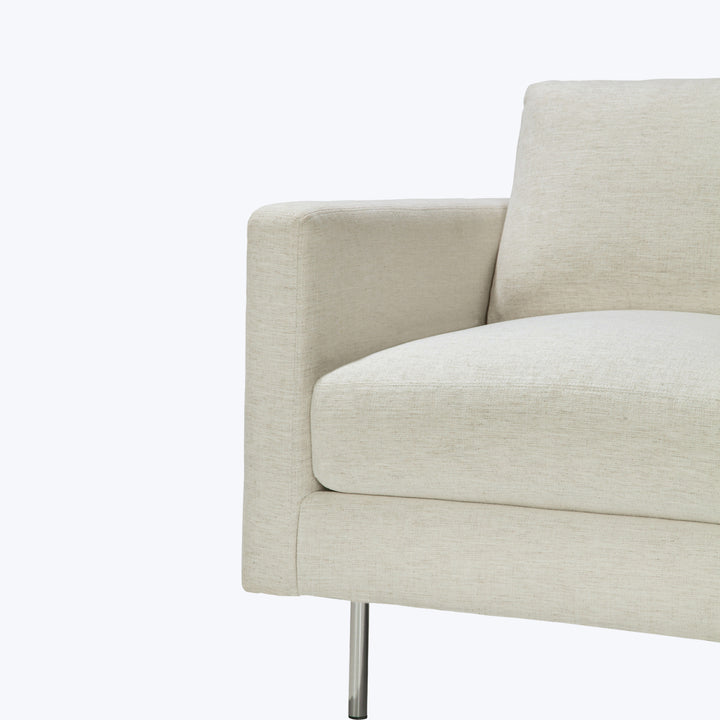 Modern sofa with clean lines, plush cushion, and metallic leg.