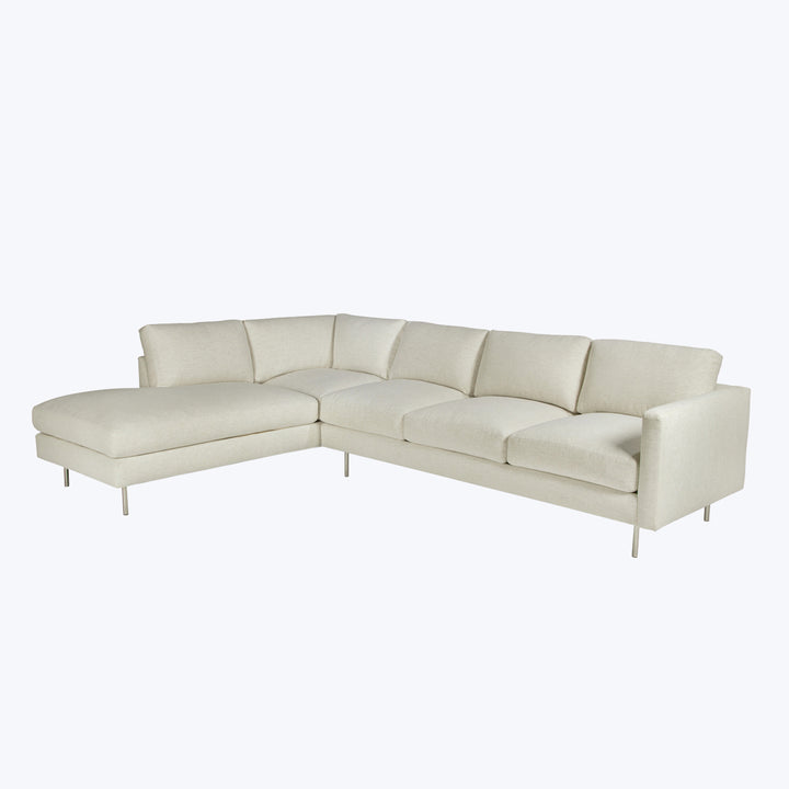 Modern L-shaped sectional sofa with plush beige upholstery and chaise.