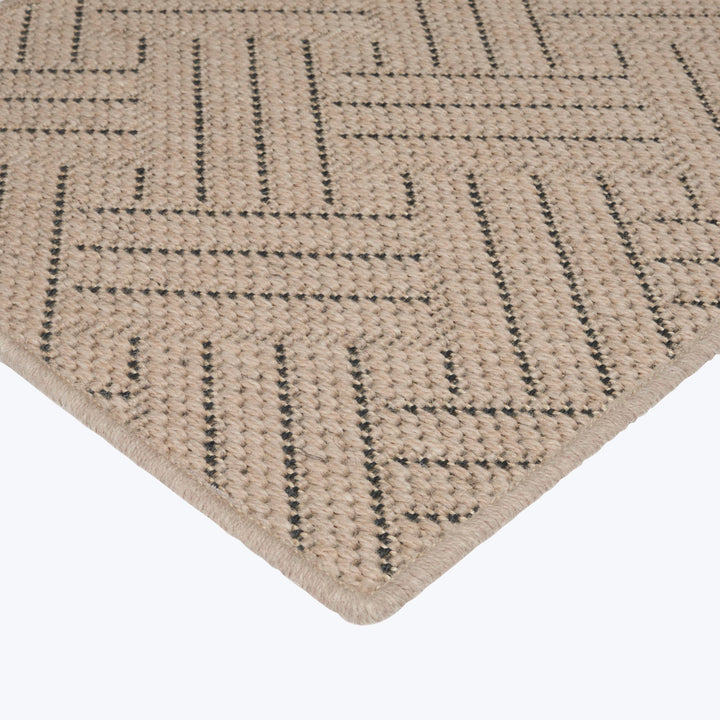 Contemporary geometric patterned rug in neutral tones with textured fabric.