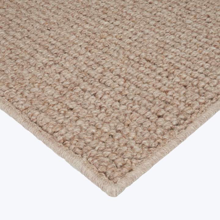 Close-up of looped boucle carpet in neutral beige color