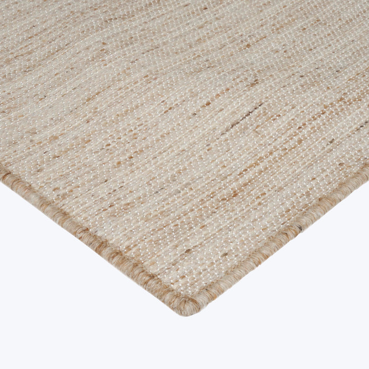 Close-up of textured rug with tight, regular weave in beige