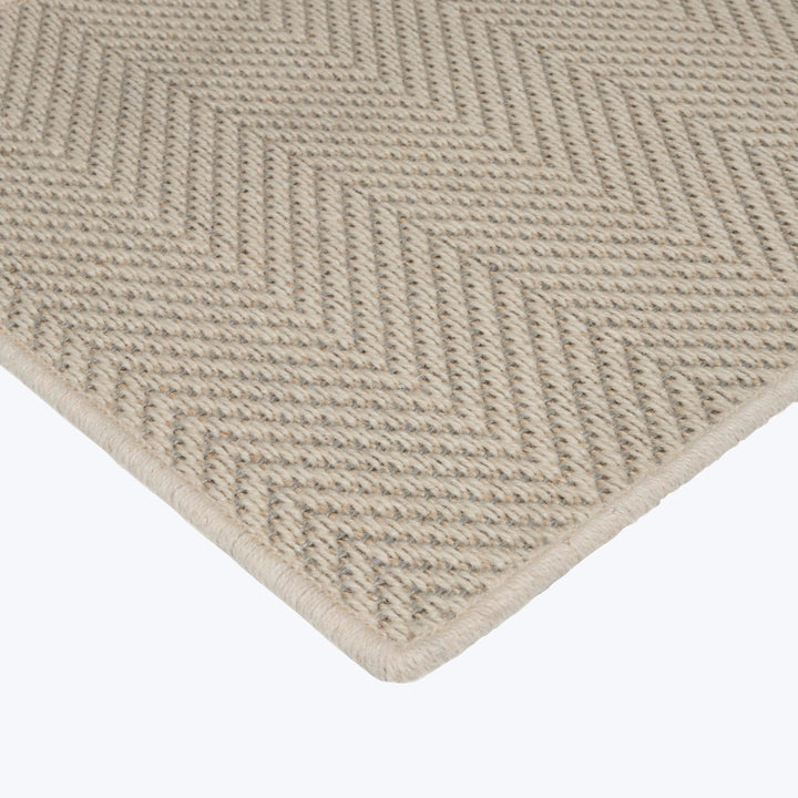 Close-up of durable herringbone rug in neutral beige color.